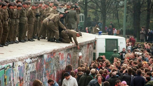 Soldati di guardia e migliaia di berlinesi che si ammassano lungo il Muro di Berlino